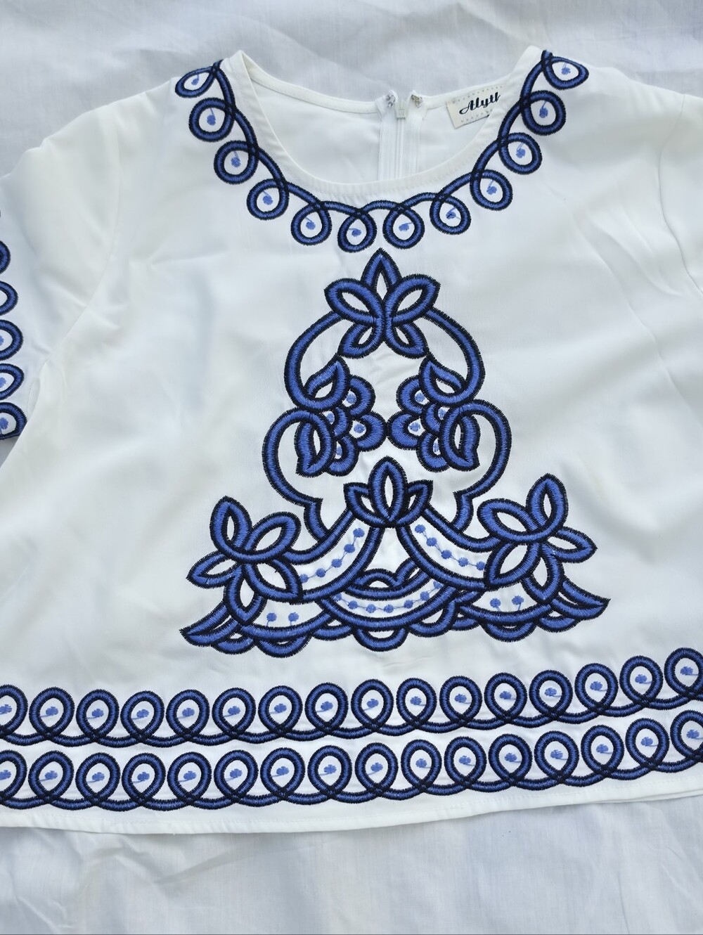 White Top with Blue Embroidered Detail